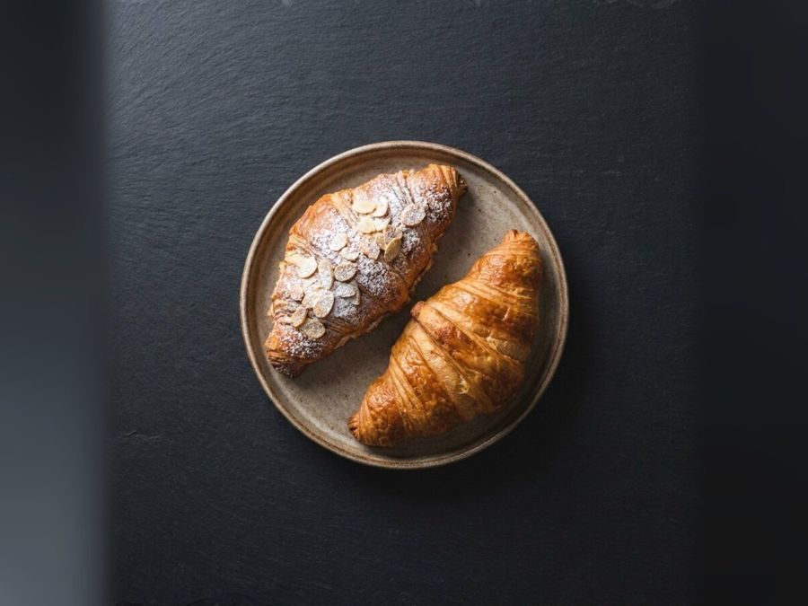 Butter croissant from the bakery counter at Nima Cafe, golden and flaky, on a plate