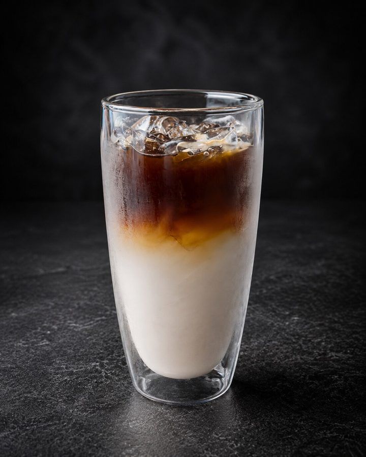 Coconut coffee at Nima Cafe: espresso poured over young coconut water and ice in a tall glass