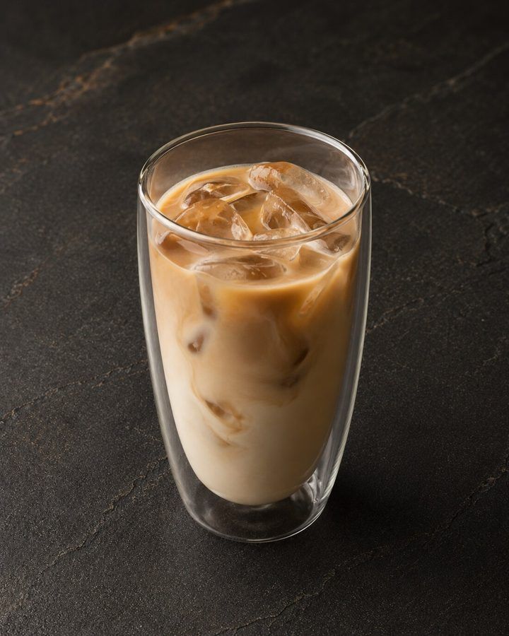Es-Yen Thai iced coffee at Nima Cafe in a tall glass with ice and milk swirling through dark coffee