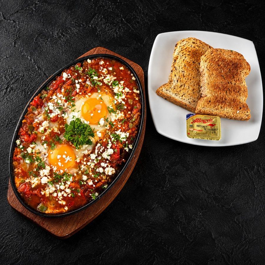 ชักชูก้าที่ Nima Cafe: ไข่อบในซอสมะเขือเทศและพริกหวานในกระทะ เสิร์ฟกับขนมปัง